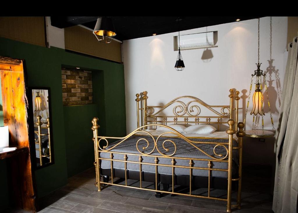 1 dormitorio con 1 cama en una habitación con paredes verdes en Casa Maria Jimena Hotel Boutique, en Chihuahua