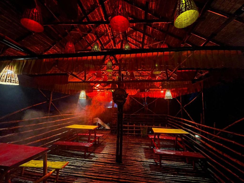 a stage with tables and chairs in a room with lights at The Sea Horse in Mandarmoni