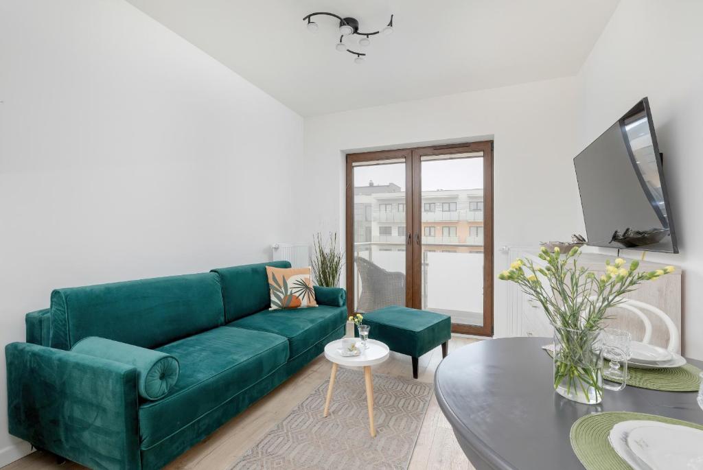 a living room with a green couch and a table at Modern Apartment 1 Maja with Parking in Kołobrzeg by Rent like home in Kołobrzeg