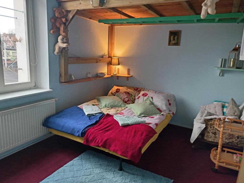 a small bed in a room with a window at - PASTELOWY loft - in Sopot
