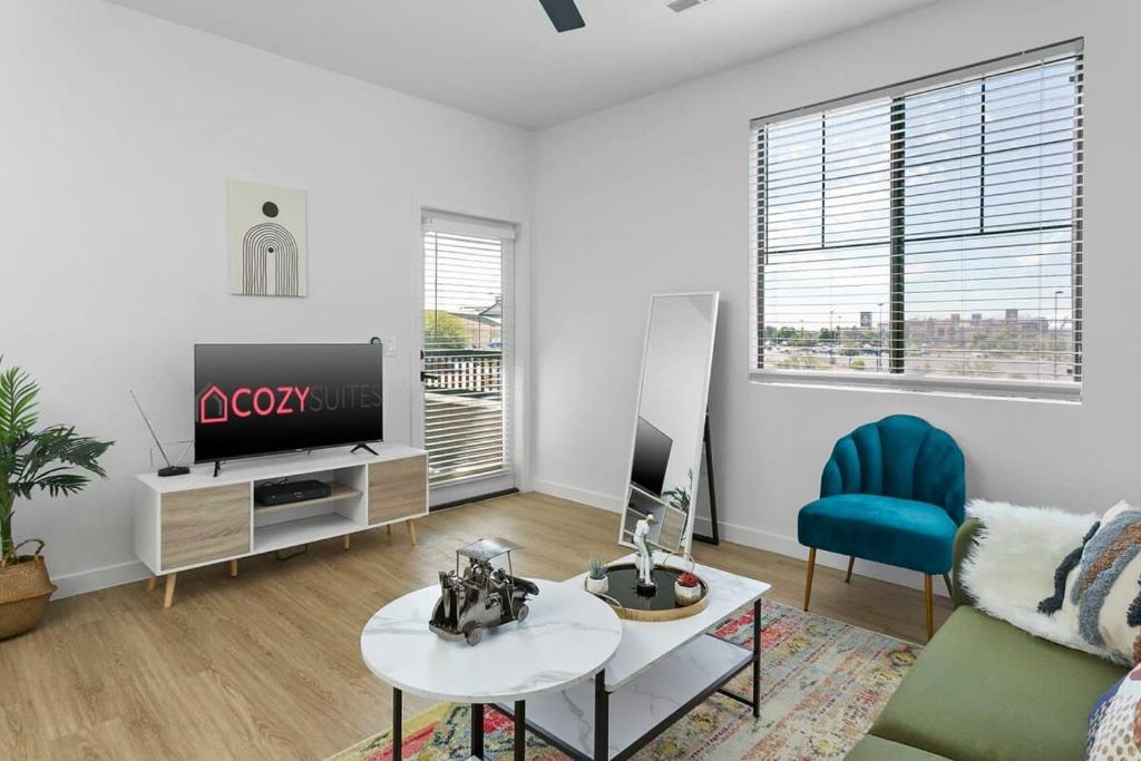 a living room with a tv and a couch and a table at CozySuites Glendale by the stadium with pool 08 in Glendale