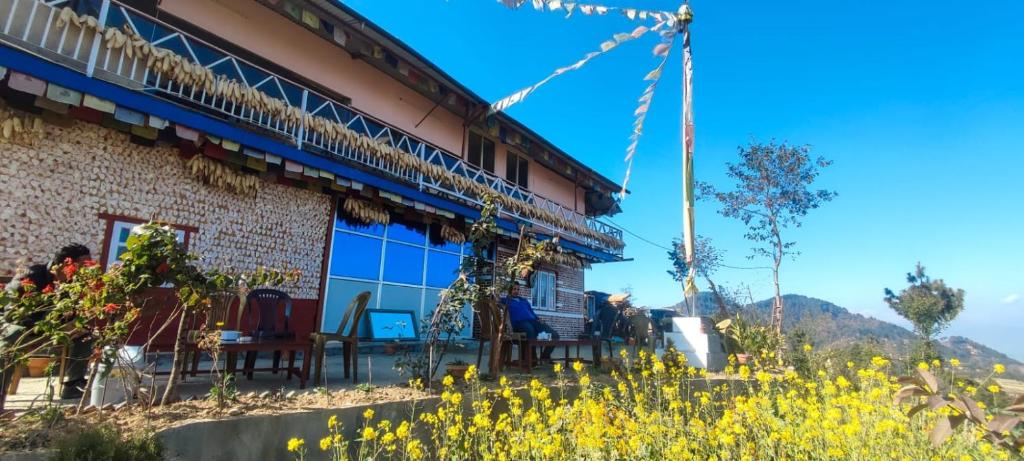 a building with chairs and flowers in front of it at Dadaghare Homestay & View Point Restaurant in Panauti
