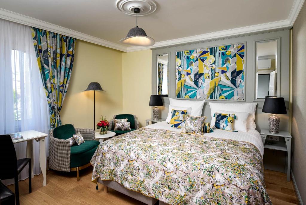 1 dormitorio con 1 cama grande y colcha colorida en Hotel The Rose by Goeres, en Luxemburgo