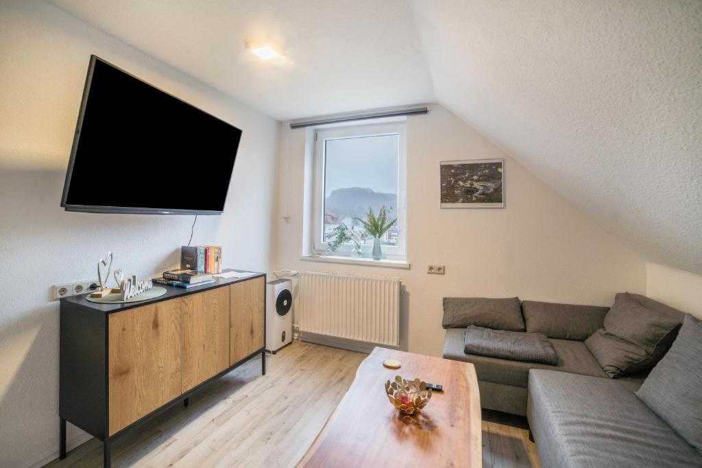 een woonkamer met een bank en een flatscreen-tv bij Ferienwohnung 2 in Bad Lauterberg