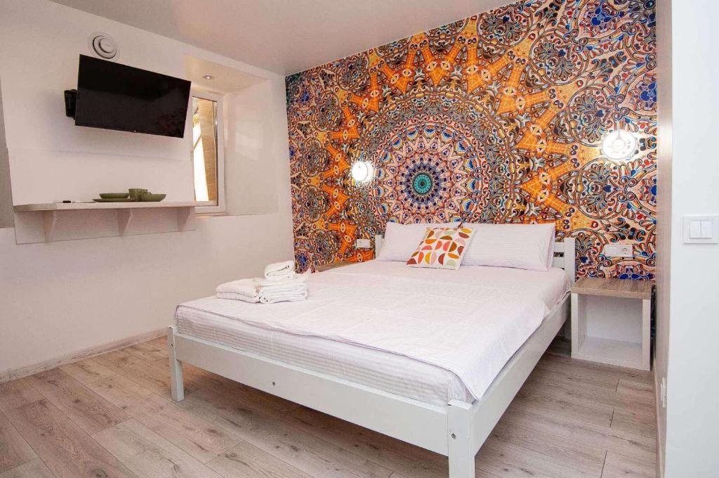 1 dormitorio con 1 cama con un mural en la pared en Apart Hotel Lyon d'Opera en Odesa