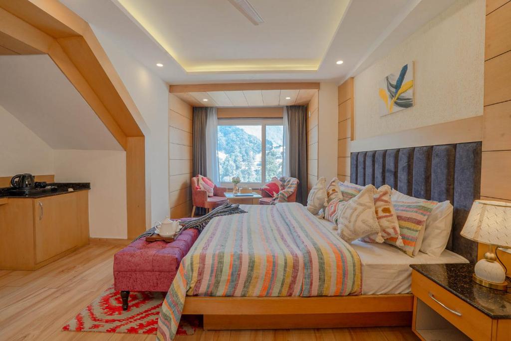 ein Schlafzimmer mit einem großen Bett mit einem rosa Stuhl in der Unterkunft Super Hotel by Perfectstayz Mall Road in Masuri