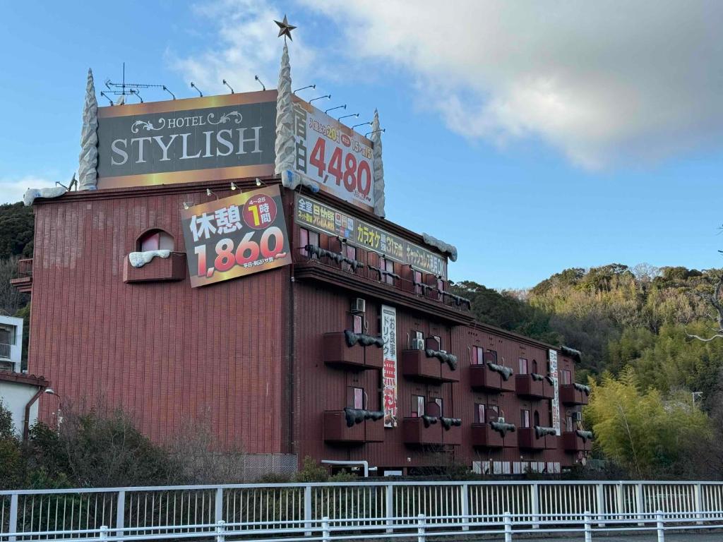 un edificio con letreros en el costado en STYLISH, en Kobe