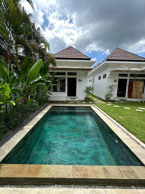 a swimming pool in front of a house at Susurro Residential in Kuta Lombok