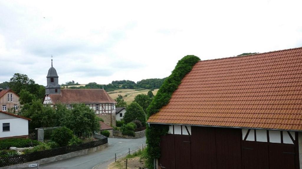 a village with a red roof and a church at Marja Ferienwohnung in Oberorke
