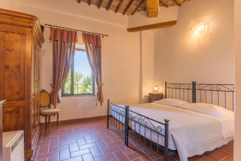 um quarto com uma cama e uma janela em Il Canto del Sole em Monteroni dʼArbia