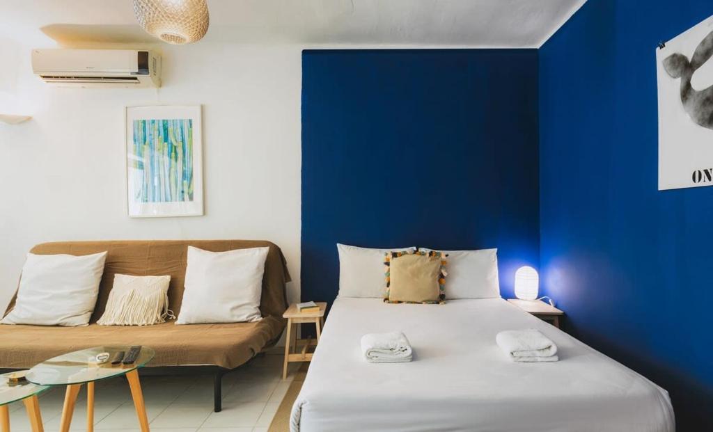ein blaues Zimmer mit einem Bett und einem Sofa in der Unterkunft Designed & Cozy Studio Near by Dizingoff Sqr. in Tel Aviv
