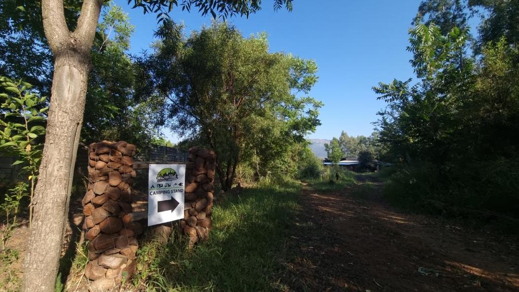 a pile of fire wood next to a tree at HOLLYBROOKE Campsites in Skeerpoort