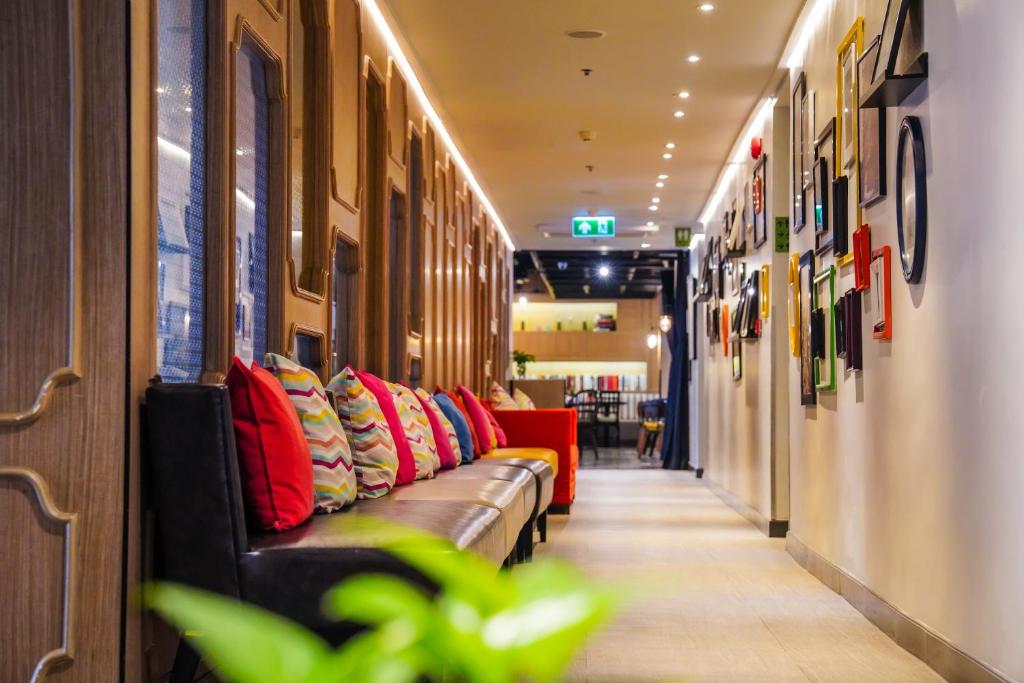 A bright corridor offers a row of cushioned seating beside framed artwork.