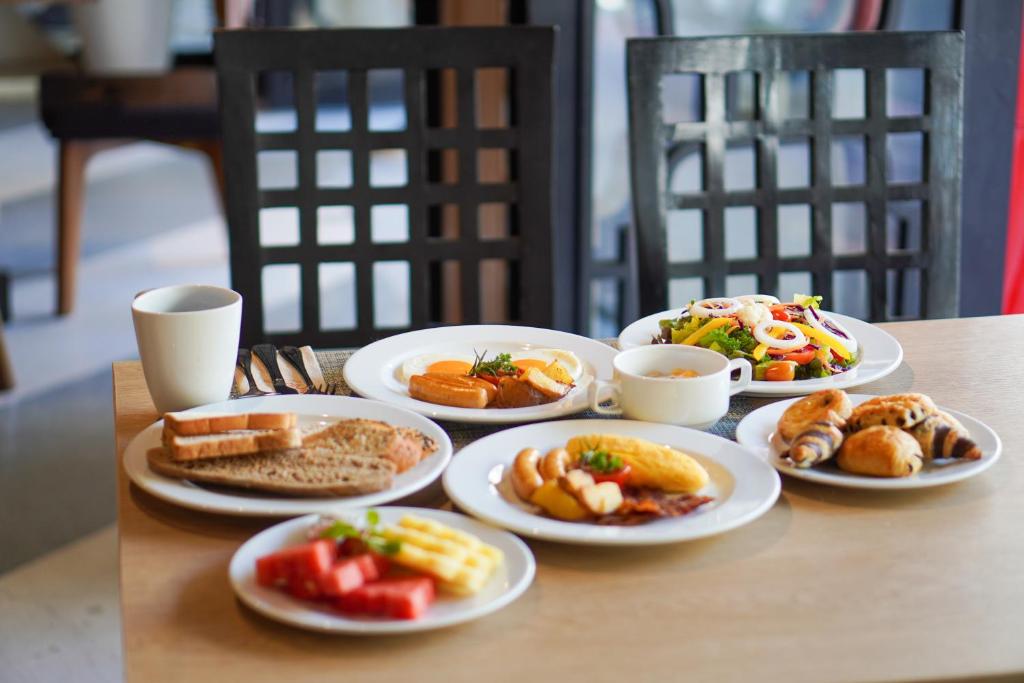 A smaller breakfast table presents bread, fruit, pastries, salad, and hot dishes.