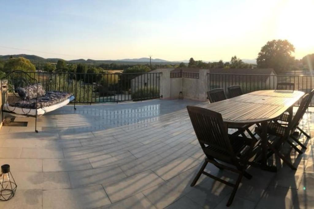 une terrasse en bois avec une table et des chaises dessus dans l'établissement gite entre mer et montagne, à Savignargues
