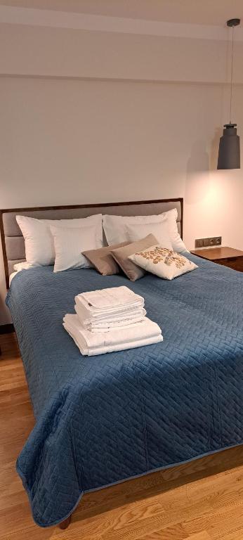 Una cama azul con toallas blancas encima. en Falcon Apartment Center 2 Metro Złote Tarasy en Varsovia