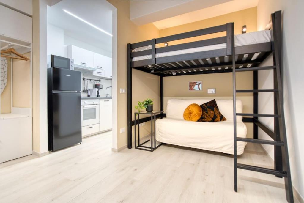 sypialnia z łóżkiem piętrowym i kuchnia w obiekcie Apartment Suzzani 273 - Interno A1 w Mediolanie