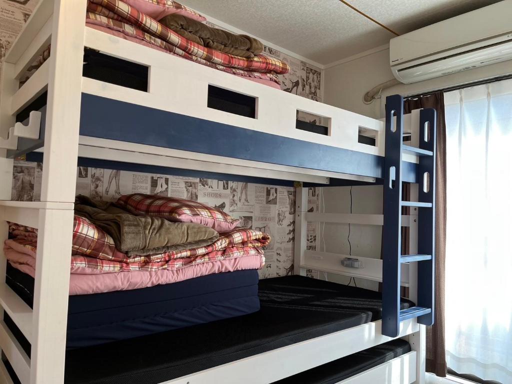 Pokój z łóżkiem piętrowym i 2 łóżkami piętrowymi w obiekcie Guest House Fukuoka W302 w mieście Kasugabaru