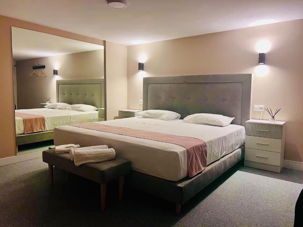 マドリードにあるRooms Luxury Madridのベッドルーム1室(ベッド2台、大きな鏡付)