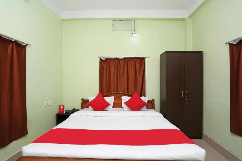 1 dormitorio con 1 cama grande con almohadas rojas en Goroomgo Somnath Puri, en Puri