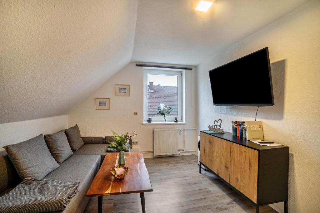 ein Wohnzimmer mit einem Sofa und einem Flachbild-TV in der Unterkunft Ferienwohnung 3 in Bad Lauterberg