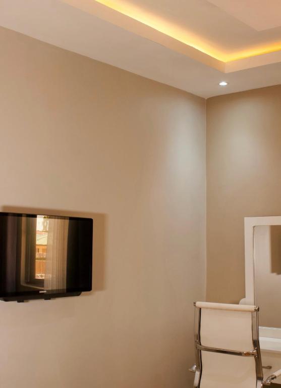 盧薩卡的住宿－Milestone Hotels，墙上配有平面电视的房间
