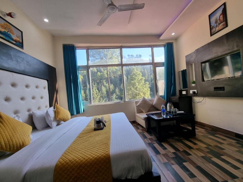 um quarto com uma cama grande e uma janela grande em Hotel Stay Well em Banikhet