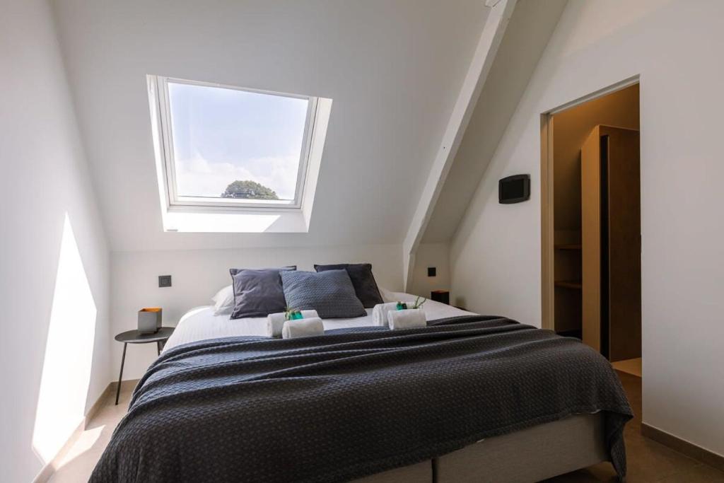 een slaapkamer met een groot bed en een raam bij Nadia - Family room at ranch "De Blauwe Zaal" in Brugge