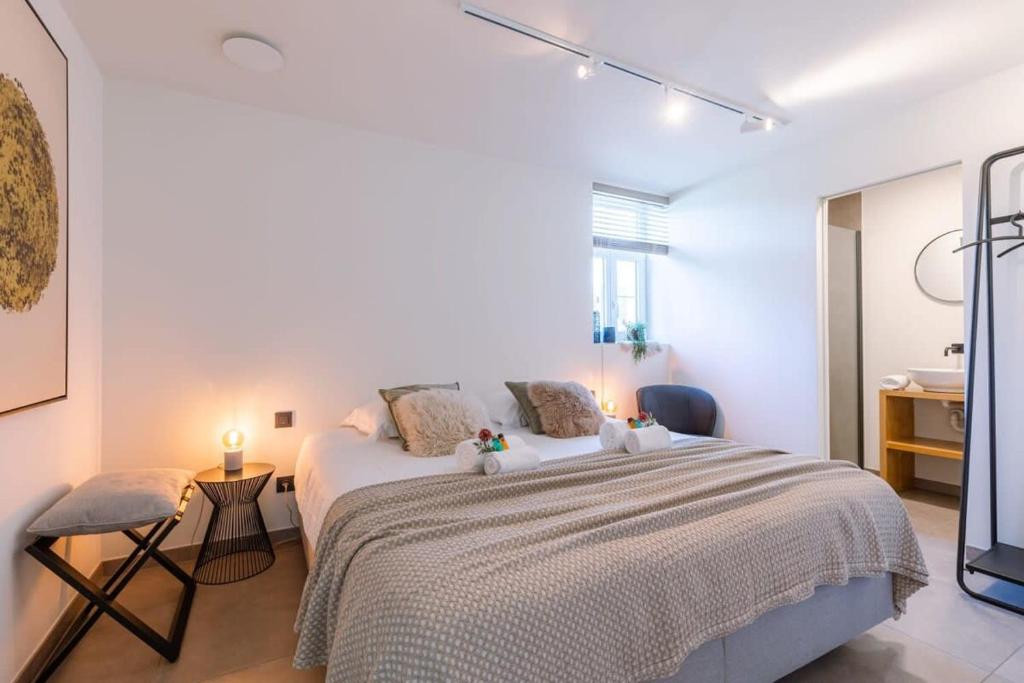 een witte slaapkamer met een groot bed en een bureau bij Quick - Charming double room at ranch "De Blauwe Zaal" in Brugge