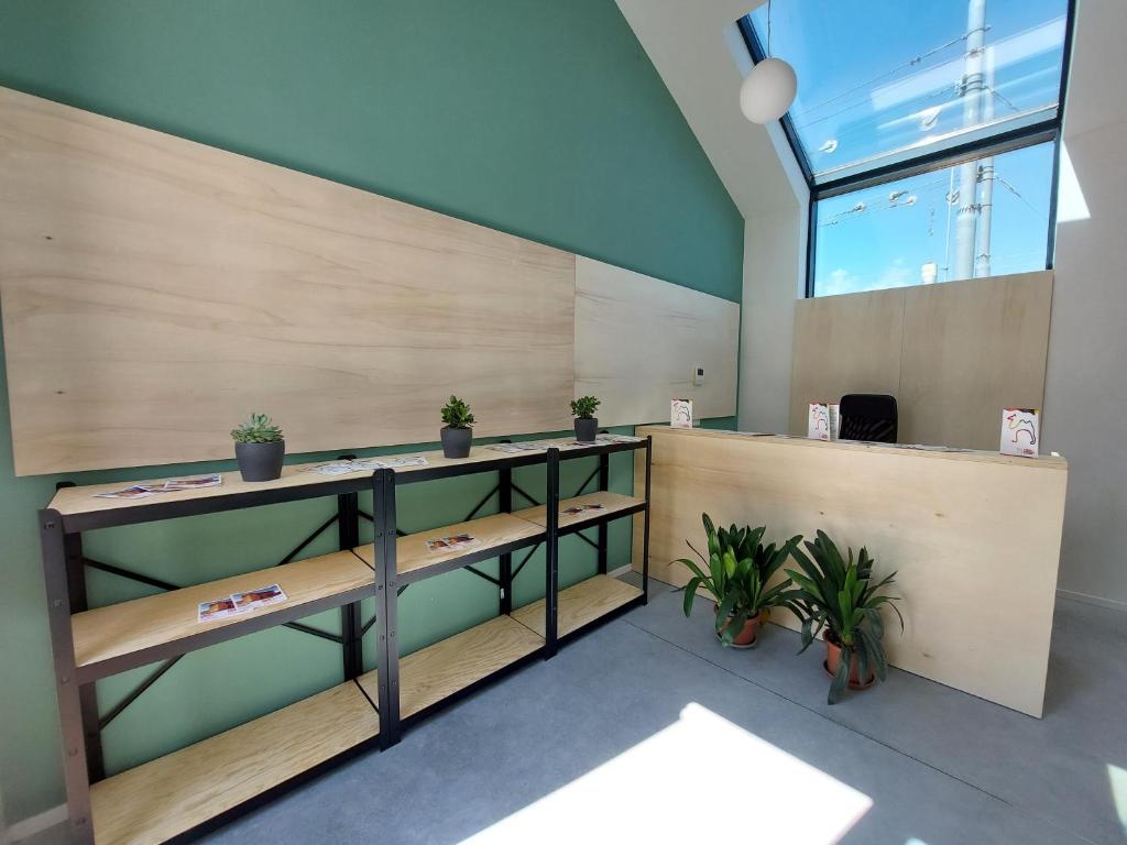 an office with wooden shelves and potted plants at Bed & Bike Hostel in San Giovanni in Persiceto