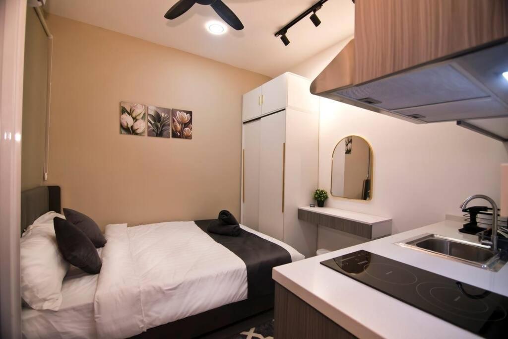 een kleine slaapkamer met een bed en een wastafel bij NeuSuites Two Bedroom in Kuala Lumpur