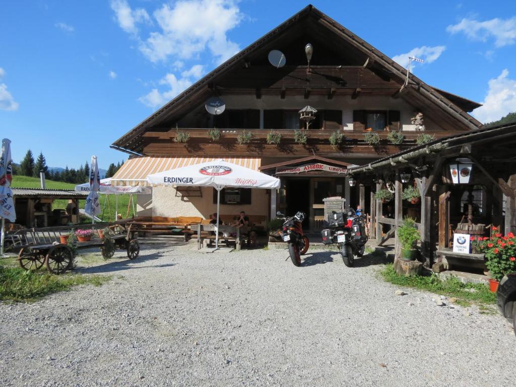 a building with an umbrella and motorcycles in front of it at Bed&Breakfast Anž'k in Bled