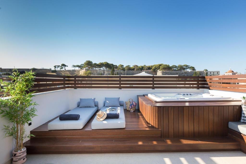 a rooftop deck with a hot tub and a bench at Le Bijou Luxury Suites Rethymno in Rethymno Town