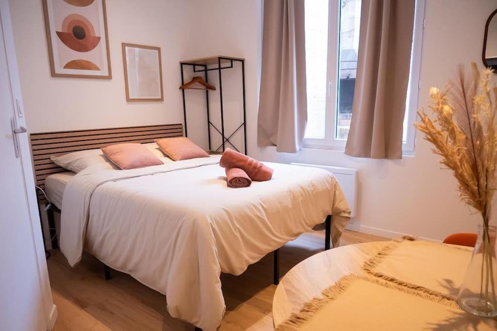 une chambre avec un lit avec deux oreillers dessus dans l'établissement Studio Paisible 2pers wifi gare, à Saint-Quentin