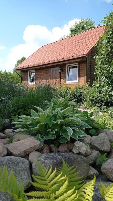 a house with a rock garden in front of a house at Uroczy domek na Mazurach in Nowe Kiejkuty