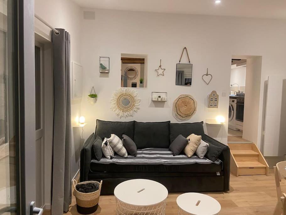 un salon avec un canapé noir et une table dans l'établissement Maisonnette La petite Jeanne, à Boves