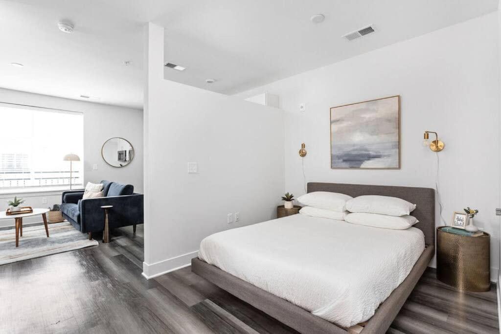 a white bedroom with a bed and a living room at Mid-Century Modern Studio CozySuites Downtown in Indianapolis