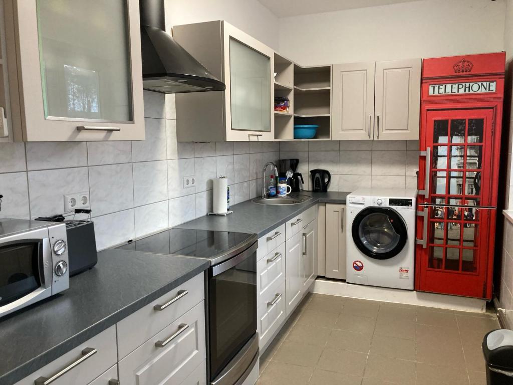 eine Küche mit weißen Schränken und einem roten Kühlschrank in der Unterkunft Schulungszentrum Töplitz in Leest