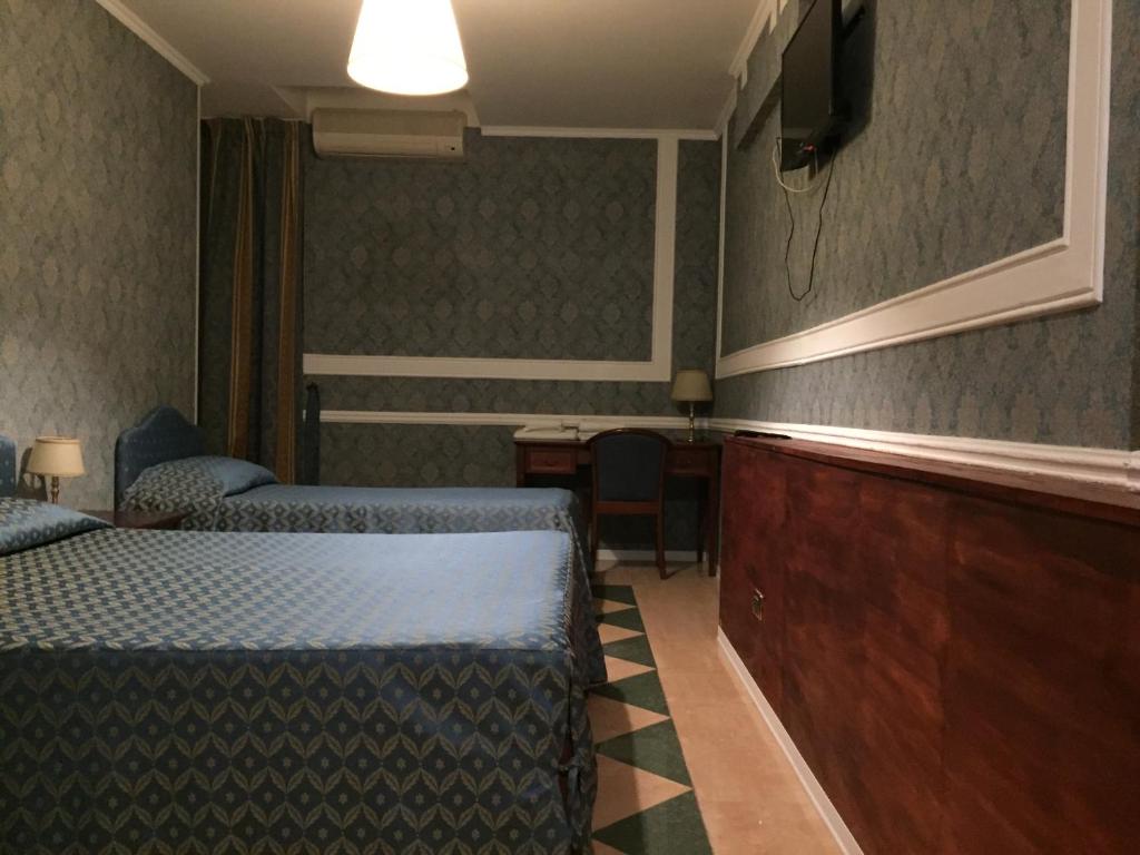科森扎的住宿－Hotel Excelsior，酒店客房设有两张床和电视。