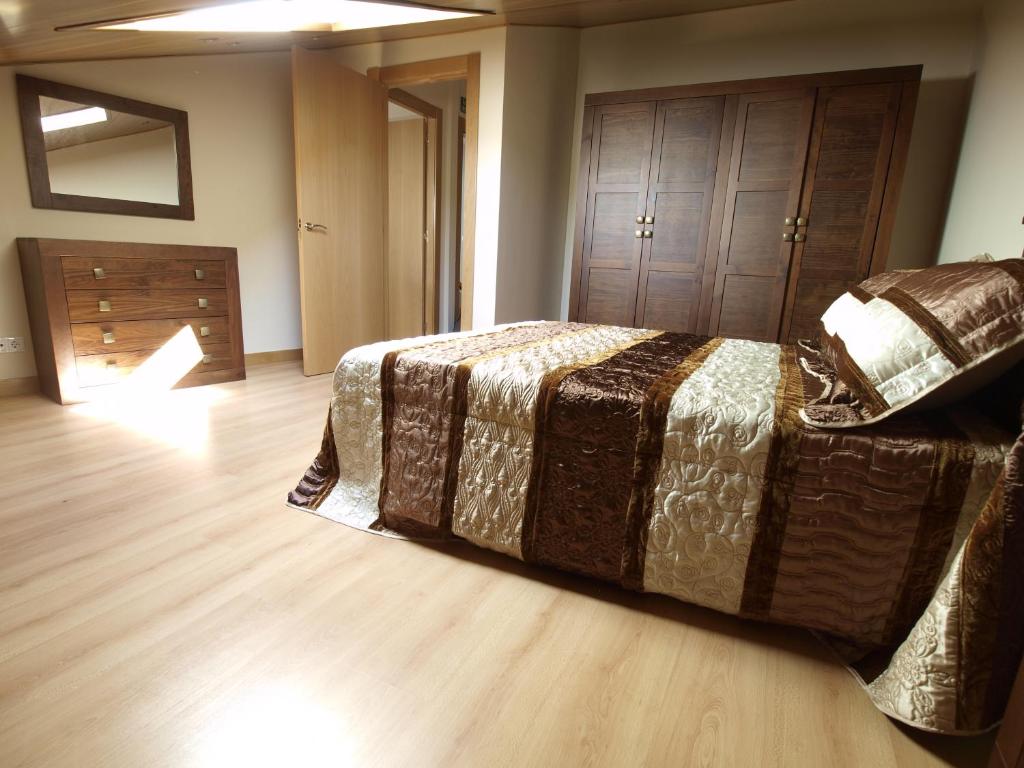 a bedroom with a bed and a wooden floor at Casa Rural El Cipres in Santo Domingo de Silos