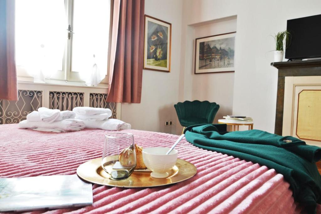 a hotel room with a bed with a tray on it at Casa Del Teatro in Pavia