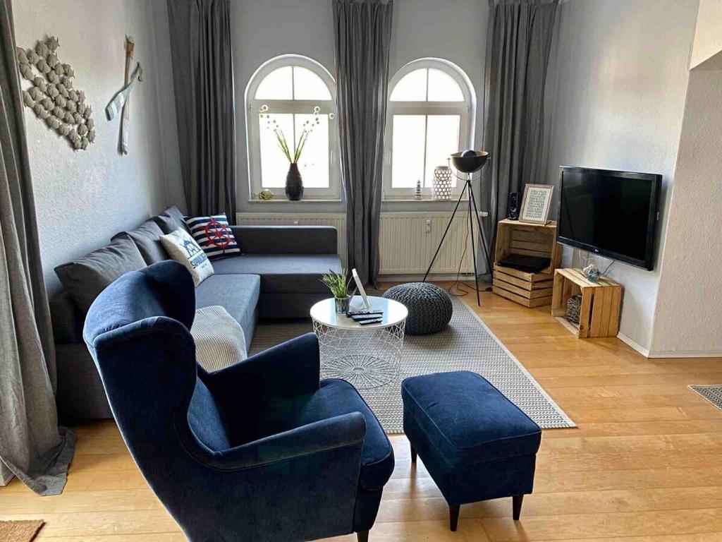 グラール・ミューリッツにあるdiscovAIR Graal-Müritz -Villa Victoria- Strandnah mit Netflixのリビングルーム(青いソファ、椅子付)