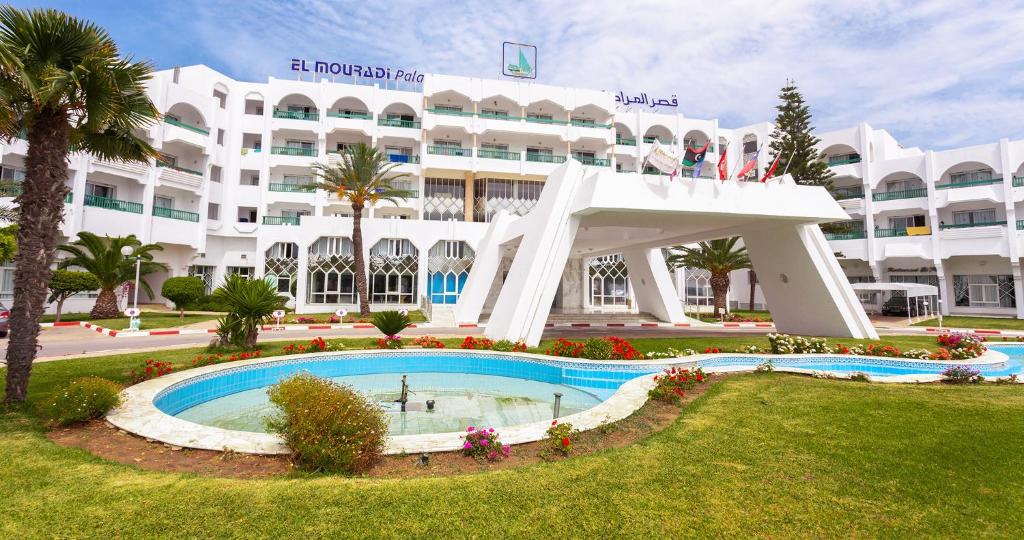 un gran edificio blanco con una piscina frente a él en El Mouradi Palace en Port El Kantaoui