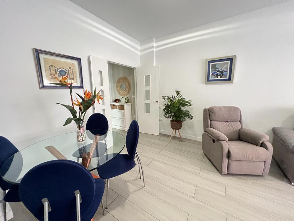 een woonkamer met een glazen tafel en stoelen bij TODIMER Apartamento lujo in Motril