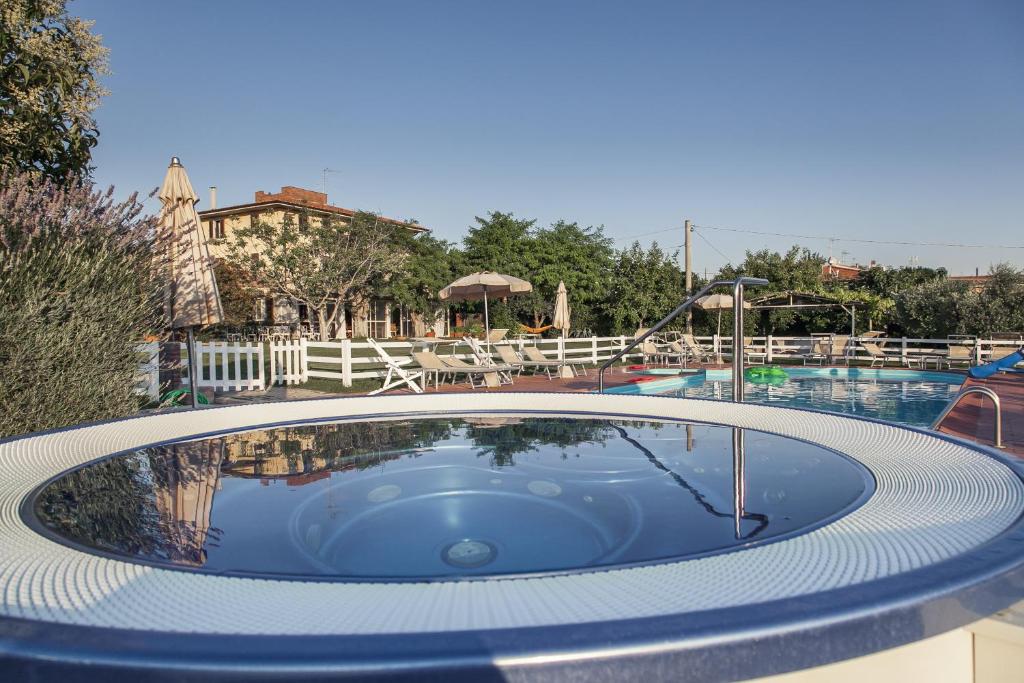 a pool with a hot tub in the middle of a resort at Agriturismo Podere L'Agave in San Vincenzo