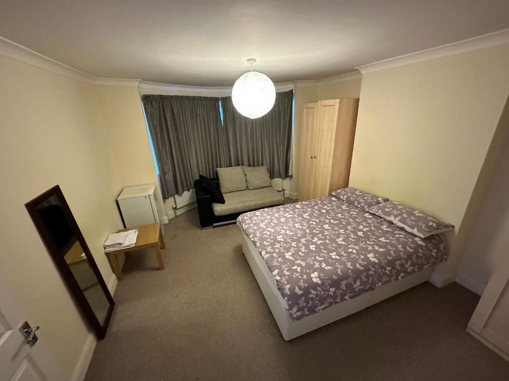 1 dormitorio pequeño con 1 cama y 1 sofá en House Dollis Hill, en Londres