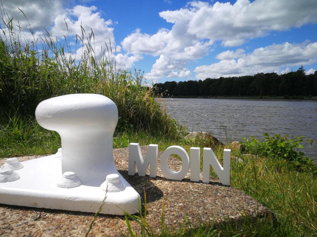 a sign that says mom next to a body of water at Gästehaus Nord-West 1700 - Doppelzimmer Beach in Steenfeld
