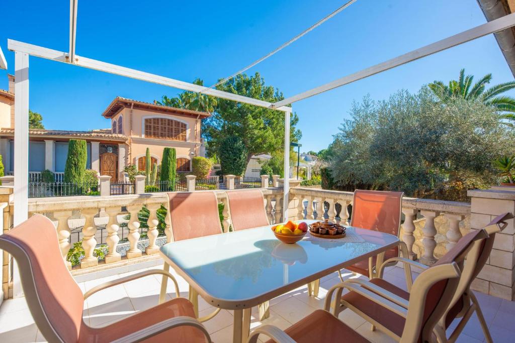 a patio with a table and chairs on a balcony at North House in Playa de Muro