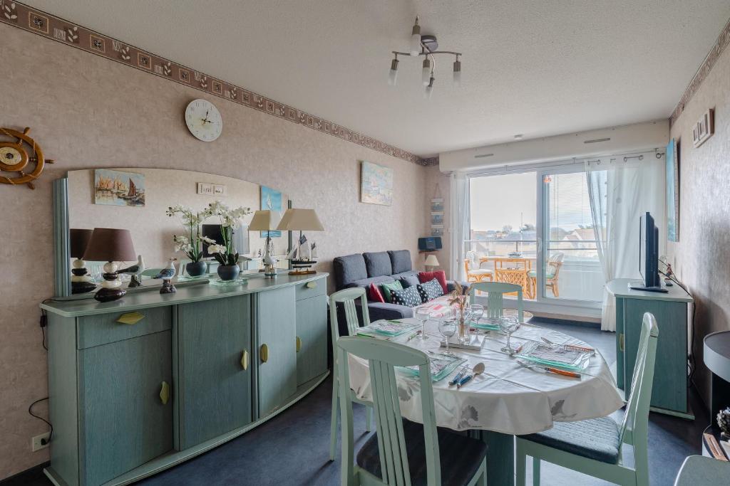 ein Wohnzimmer mit einem Tisch und einem Esszimmer in der Unterkunft L'Abri du Cap Horn - Proche plage pour 4 in Courseulles-sur-Mer