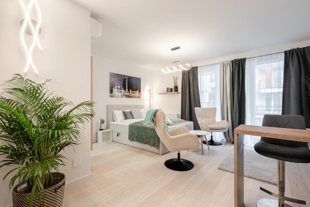 a white bedroom with a bed and a table and chairs at Heroes Square Apartment in Budapest